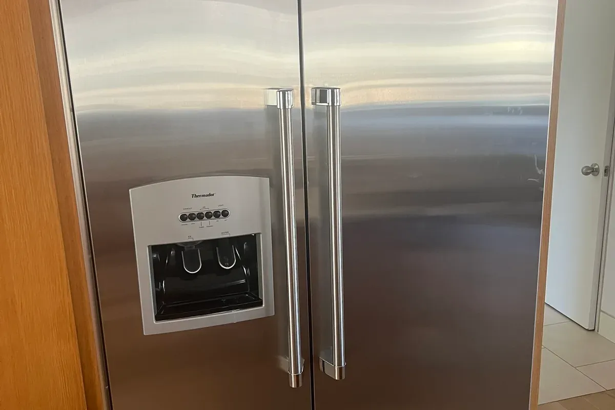 Technician from Appliance Repair Now diagnosing a refrigerator in a Fort Worth kitchen