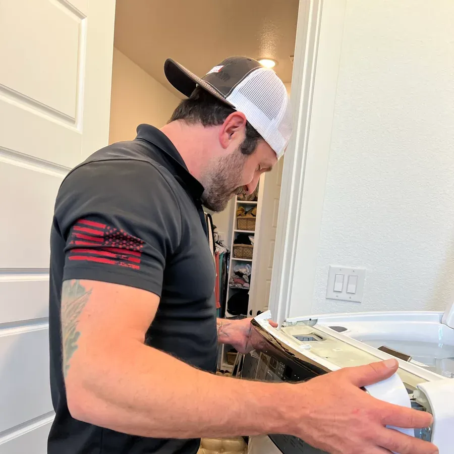 Technician working on a built-in stainless refrigerator